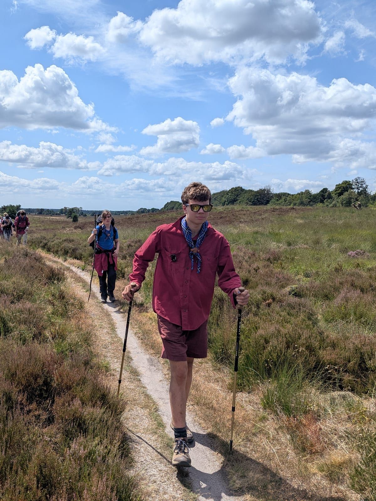 Explorer met wandelstokken op een heidepad tijdens een hike