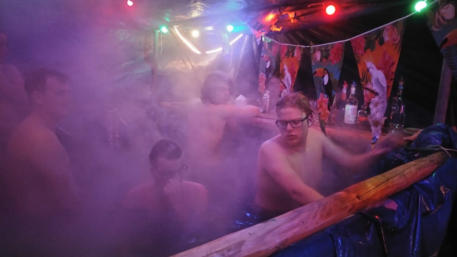 Stamleden vieren feest in de bar, tussen de rook en het gekleurde licht