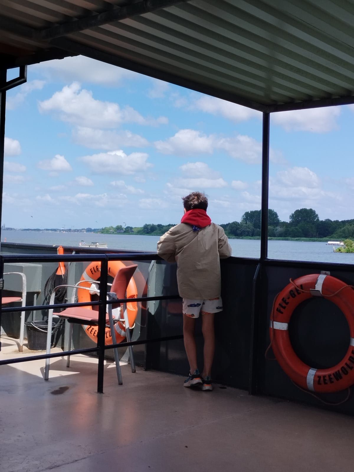 Scout kijkt uit over het water vanaf het dek van een boot