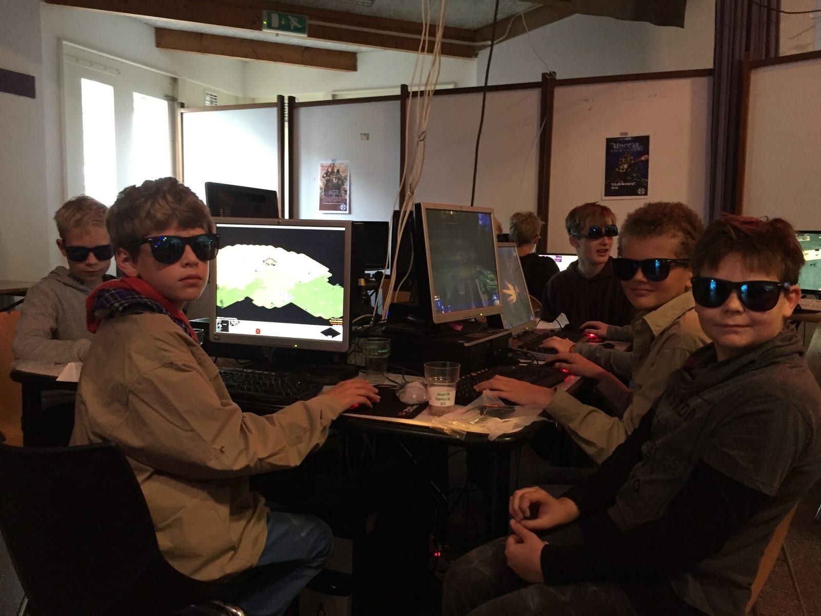 Een rij scouts met zonnebril op achter de computers